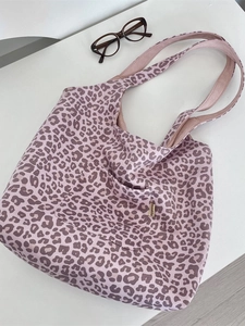 Chic pink leopard print suede shoulder tote bag with front pocket on white background