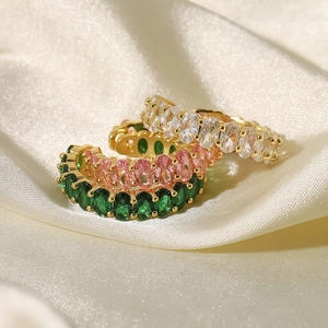 Detailed close-up of 18k gold rings featuring white, pink and green oval-cut zircons