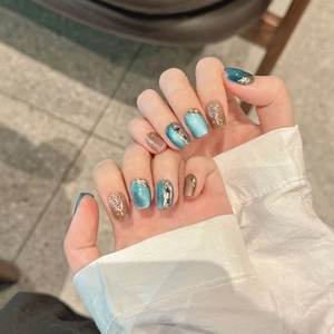 Neon cat-eye press-on nails with blue gems, gold relief lines and heart pattern detail