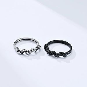 Detailed close-up of intertwined wire texture on silver and black stainless steel rings