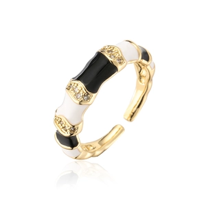 Detailed view of bamboo-style gold ring with black and white enamel and zircon stones