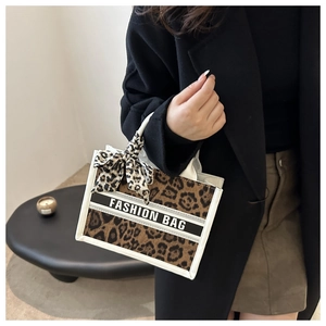 Detailed shot of leopard print tote bag with white trim and Fashion Bag text detail