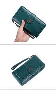 Detail view of dark green pebbled leather wallet with U-shaped punching and metal buckle