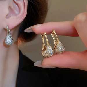 Vue détaillée de boucles d'oreilles dorées en U avec zircons micro-pavés et fermoir