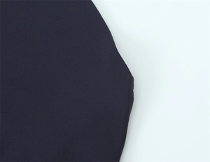 Détail de la robe longue dos nu bleu marine montrant les coutures et la texture du tissu fin