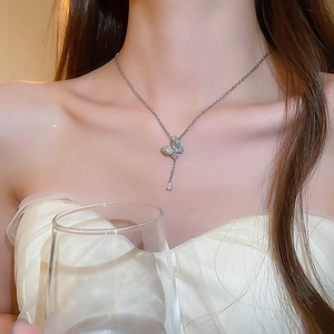Detail of silver butterfly pendant necklace with zircon rhinestones and teardrop charm