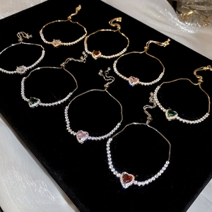 Adjustable tennis bracelets with colorful heart-shaped stones on black velvet