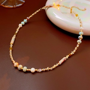 Detailed close-up of handmade beaded necklace with turquoise and baroque pearls on leather