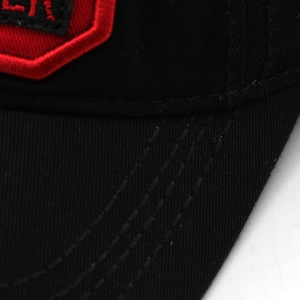 Macro shot of red embroidery on black cotton baseball cap with multi-row stitching detail