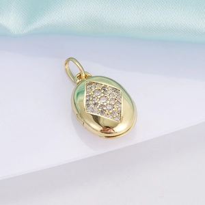Detail view of 18K gold plated oval pendant with inlaid zircon diamond pattern on silk fabric