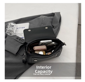 Interior view of black leather crossbody bag showing multiple pockets and storage capacity