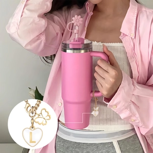 Pink tumbler detail featuring flower straw cover and golden chain with letter L heart charm