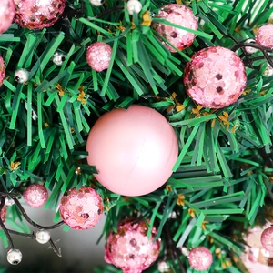 Pink Christmas wreath with matte and glitter baubles on green faux pine branches