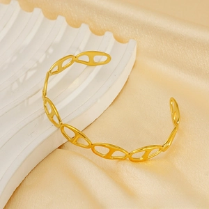 Detail view of gold stainless steel open bangle with hollow oval chain link pattern