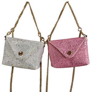 Close-up of sparkling sequin envelope bags in white and pink with gold metal chains