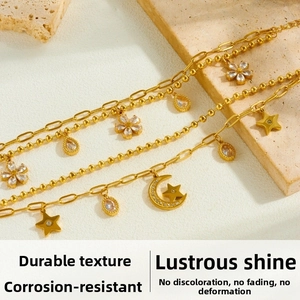 Detail of gold-plated stainless steel star and moon pendants with zircon accents on double chain