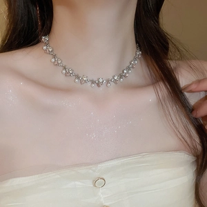 Close-up of elegant pearl and rhinestone heart pendant necklace on a model's neck