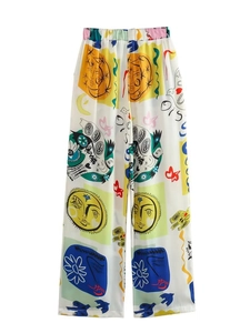 Détail d'un pantalon large taille haute pour femme avec imprimé abstrait soleil et visage
