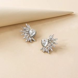 Close-up of wing-shaped rhinestone earrings with heart crystal in silver alloy base