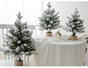 Three flocked snowy mini Christmas trees with round wooden bases for festive home decor