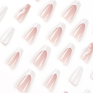 Lange Sargnägel zum Aufkleben mit weißen Glitzer-French-Tips und floralen Strasssteinen