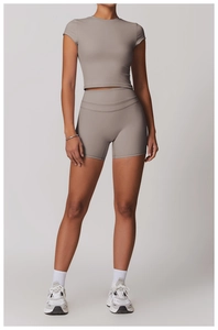 Dettaglio degli shorts da yoga taupe a vita alta e del crop top con tessuto spazzolato