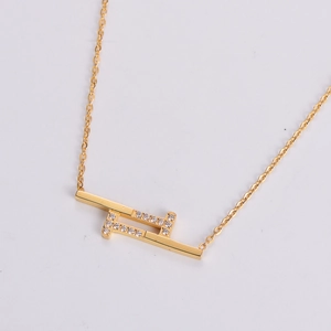 Macro view of geometric gold pendant with sparkling zircon inlay on fine link chain