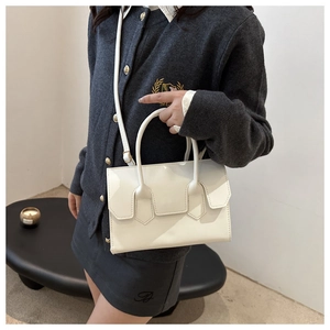 Minimalist white leather crossbody bag shown on model for size and style perspective