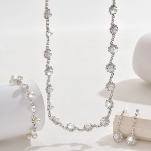 Luxurious bridal jewelry set with silver rhinestones and pearls on white display