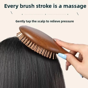 Close-up of sandalwood air cushion brush massaging long black hair on a soft beige background
