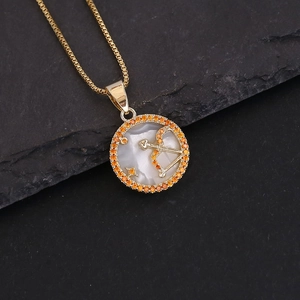 18K gold Sagittarius constellation necklace with shell inlay and orange stones on dark stone