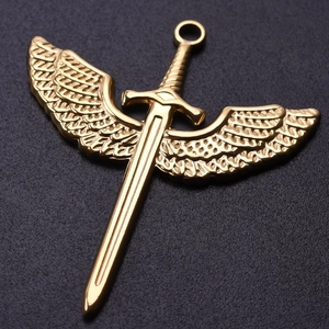 Macro shot of 18k gold plated stainless steel winged sword pendant with detailed feathers
