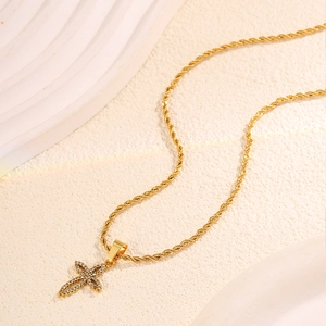 Detailed macro view of a gold cross pendant necklace with sparkling micro-pave zircons