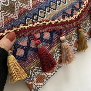 Close-up of bohemian woven bag with ethnic jacquard patterns and silk tassel details