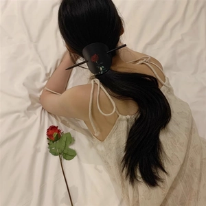 Épingle à cheveux chinoise avec imprimé rose sur cuir porté sur une queue de cheval