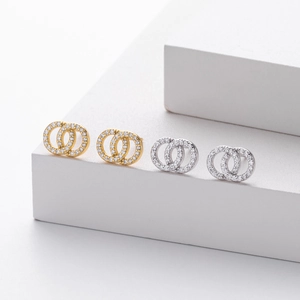 Macro shot of interlocking double hoop earrings in gold and silver with zircon pave