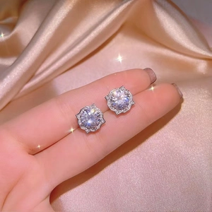 Close-up of elegant halo stud earrings with a brilliant round centerpiece and micro-pave stones