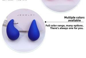 Macro detail of Klein blue teardrop earrings with a matte finish on jewelry card