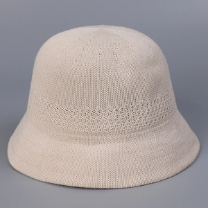 Detail of breathable knitted bucket hat with elegant hollow decorative pattern in beige
