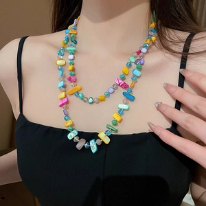 Détail d'un collier bohème multicouche en perles de verre colorées aux formes irrégulières