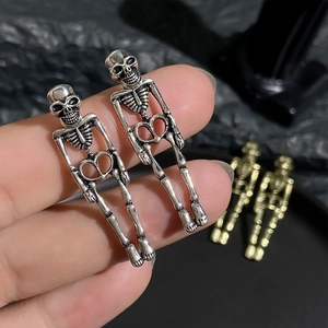 Close-up of vintage gothic skull dangle earrings showing size and antique metal texture