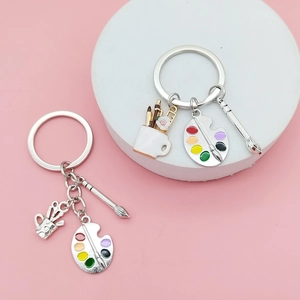 Detail of artistic metal palette and paintbrush keychain with colorful enamel coating