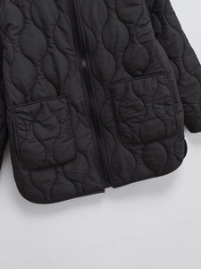 Detail of black quilted jacket with wavy stitching pattern and convenient side pockets