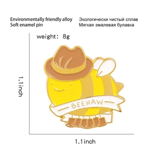 Detailed view of bee cowboy enamel pin showing 1.1x1.1 inch size and BEEHAW lettering