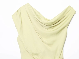 Detail of the elegant draped neckline on a pale green satin off-shoulder top