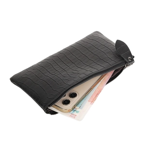 Close-up of black crocodile pattern leather wallet holding a smartphone and cash