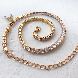 Detailed view of a gold-toned necklace featuring cubic zirconia and a crystal Letter A pendant