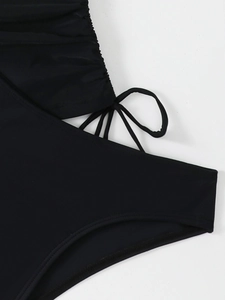 Detail view of black swimwear featuring ruching texture and side drawstring ties