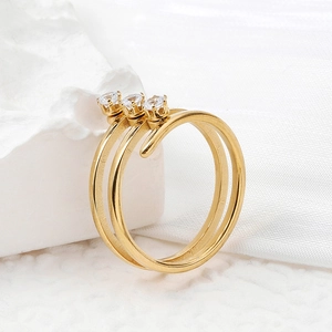 Elegant gold multi-layer wrap ring with three small diamonds on a white stone background