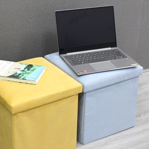 Detail of minimalist foldable storage ottoman showing soft velvet fabric and sturdy lid
